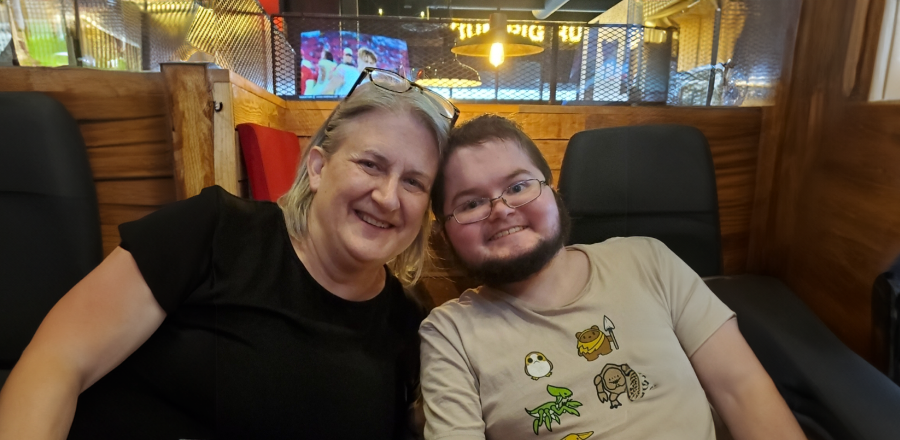 Debra and her son Alex pose together in a restaurant.