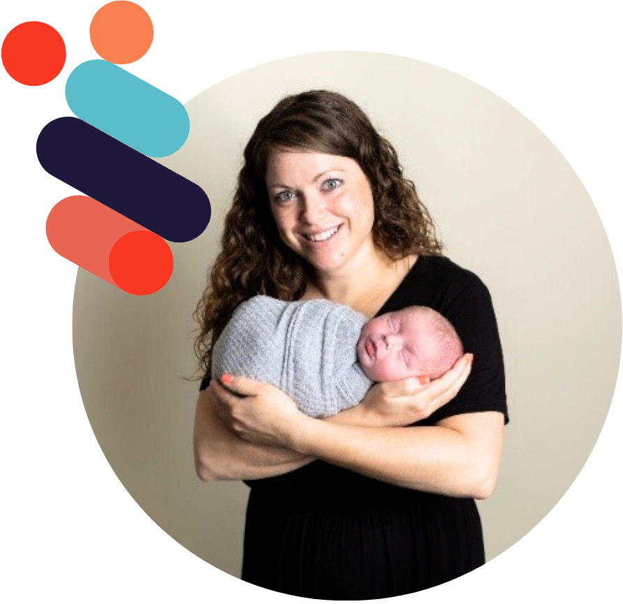 A young mother cradles her newborn baby who is swaddled in a grey blanket.