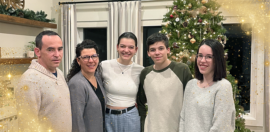 Julie and her family in front of their Christmas tree.